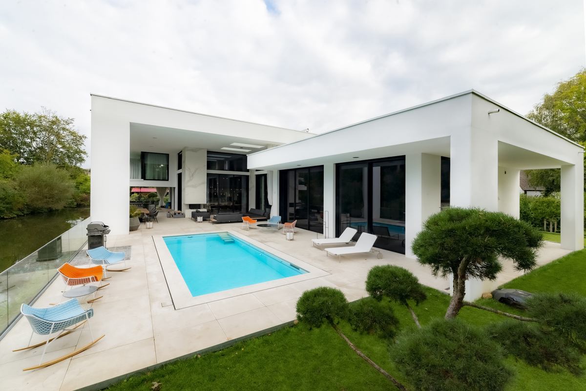 Ở ph&iacute;a sau, ng&ocirc;i nh&agrave; c&oacute; một hồ bơi tập trung trong một boong rộng r&atilde;i với tầm nh&igrave;n ra s&ocirc;ng.